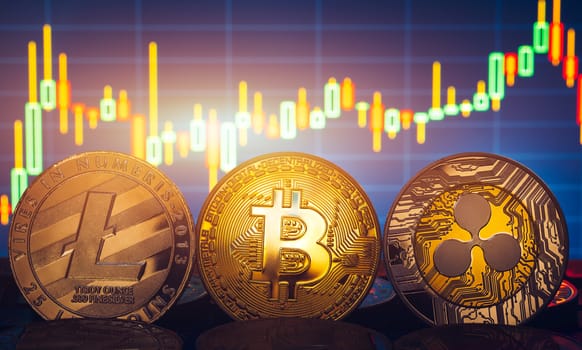 Bitcoin, litecoin and ripple coins currency finance money on graph chart background. Bitcoin as most important cryptocurrency concept. Stack of cryptocurrencies with a golden bitcoin in the middle.