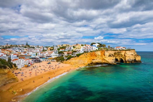 View of Carvoeiro fishing village with beautiful beach, Algarve, Portugal. View of beach in Carvoeiro town with colorful houses on coast of Portugal. The village Carvoeiro in the Algarve Portugal.