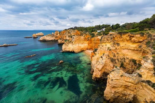 View of stunning beach with golden color rocks in Alvor town , Algarve, Portugal. View of cliff rocks on Alvor beach, Algarve region, Portugal.