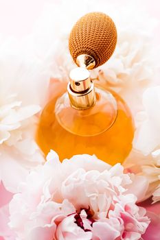 Chic fragrance bottle as citrus perfume product on background of peony flowers, parfum ad and beauty branding design