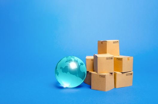 Blue glass globe and cardboard boxes. International world trade distribution. Delivery of goods, shipping. Global economy, import export freight traffic. Globalization markets. Economics development.