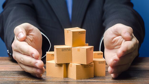 Businessman covers boxes goods. Business management. Commodity circulation import export. Support manufacturer, attracting investments, promoting products to new markets. Marketing sales, distribution