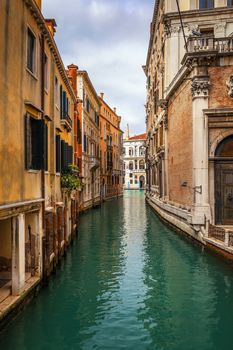 View of the street canal in Venice, Italy. Colorful facades of old Venice houses. Venice is a popular tourist destination of Europe. Venice, Italy.