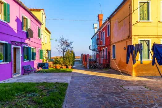 Street with colorful buildings in Burano island, Venice, Italy. Architecture and landmarks of Burano, Venice postcard. Scenic canal and colorful architecture in Burano island near Venice, Italy