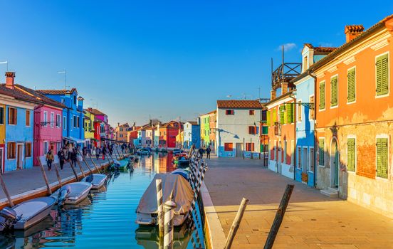 Beautiful view of the canals of Burano with boats and beautiful, colorful buildings. Burano village is famous for its colorful houses. Venice, Italy.