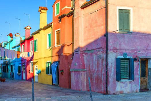 Street with colorful buildings in Burano island, Venice, Italy. Architecture and landmarks of Burano, Venice postcard. Scenic canal and colorful architecture in Burano island near Venice, Italy