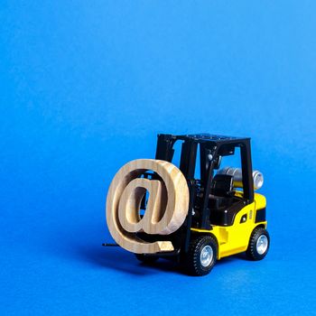 Yellow Forklift truck carry email symbol commercial AT. Integration of the industry into network technologies and Internet. E-commerce. sales of goods through online trading platforms. shopping online