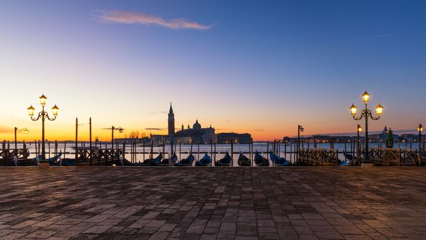 Scenic view of San Giorgio Maggiore, gondolas and lamp at colorful sunrise, Venice, Italy. Sunset in Venice. Gondolas at Saint Mark's Square and church of San Giorgio Maggiore on background, Italy, Europe