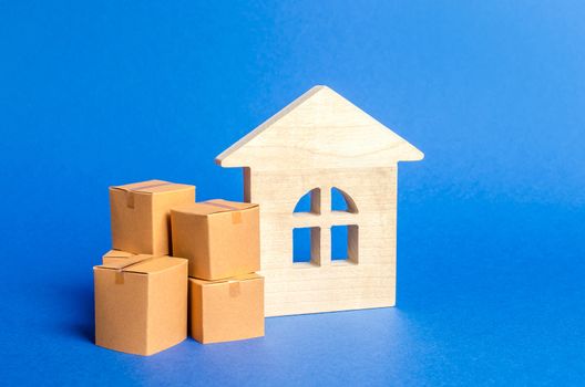 Living house and pile of boxes. Concept of moving to another house or city. beginning of a new stage of life. Property transportation. Freight shipping, goods delivery and installation