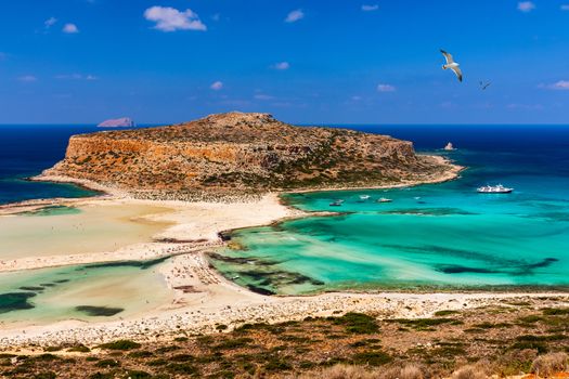 Balos Lagoon and Gramvousa island on Crete with seagulls flying over, Greece. Cap tigani in the center. Balos beach on Crete island, Greece. Crystal clear water of Balos beach.