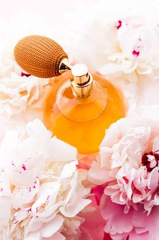 Chic fragrance bottle as citrus perfume product on background of peony flowers, parfum ad and beauty branding design