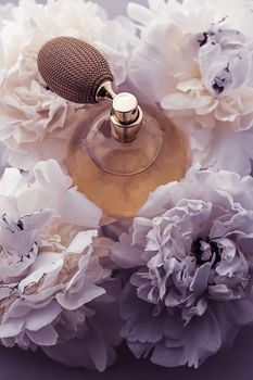 Luxe fragrance bottle as vintage perfume product on violet background and peony flowers, parfum ad and beauty branding design