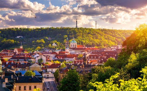 Prague red roofs and dozen spires of historical Old Town of Prague. Cityscape of Prague on a sunny day. Red rooftops, spires and the Charles Bridge and Vltava River in the background. Prague, Czechia.