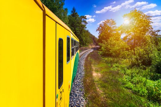 Train ride, view from a window. Old train passing green vegetation. View from the window. Traveling by train to sunset. Sunset scenery and a train gilded by sun, view from a train window. Czechia.