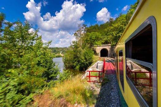 Train ride, view from a window. Old train passing green vegetation. View from the window. Traveling by train to sunset. Sunset scenery and a train gilded by sun, view from a train window. Czechia.