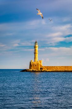 Venetian harbour and lighthouse in old harbour of Chania with seagulls flying over, Crete, Greece. Old venetian lighthouse in Chania, Greece. Lighthouse of the old Venetian port in Chania, Greece.