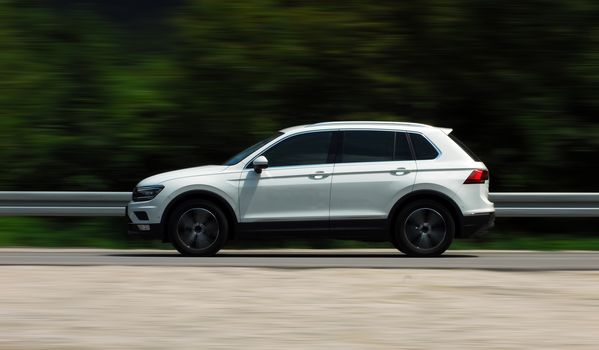 A panning shot of a speeding SUV