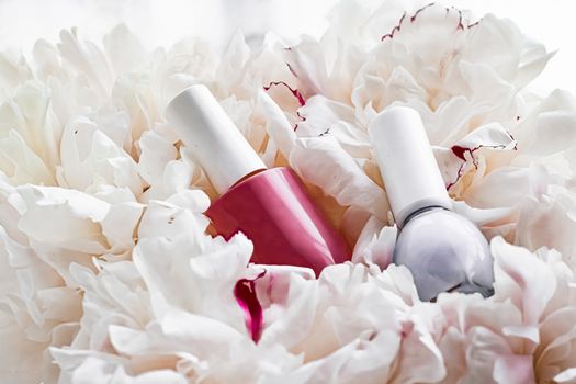 Nail polish bottles on floral background, french manicure and cosmetic branding design