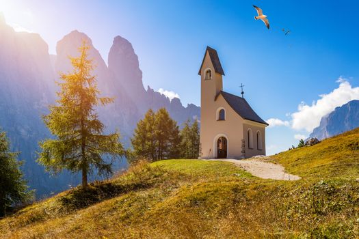 Chapel of San Maurizio at Passo Gardena, South Tyrol, Italy.  View to path to small white chapel San Maurizio and Dolomiti mountain. San Maurizio chapel on the Gardena Pass, South Tyrol, Italy.