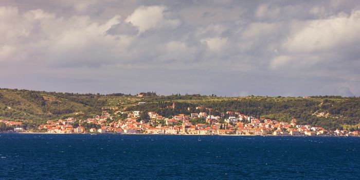 Supetar city in Brac island, Croatia. View from the sea. Picturesque scenic view on Supetar on Brac island, Croatia. Panoramic view on harbor of town Supetar from the side of sea. Brac, Croatia.