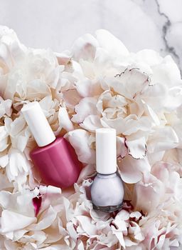 Nail polish bottles on floral background, french manicure and cosmetic branding design