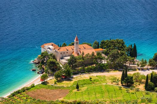 View of beautiful bay with beach and Dominican monastery in Bol town, Brac island, Croatia. Dominican monastery in Bol, built in 15th century. Bol town, Brac island, Croatia.