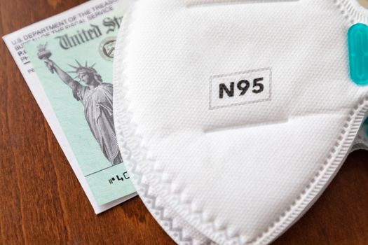 N95 Medical Face Mask Resting On IRS Covid-19 Economic Relief Check