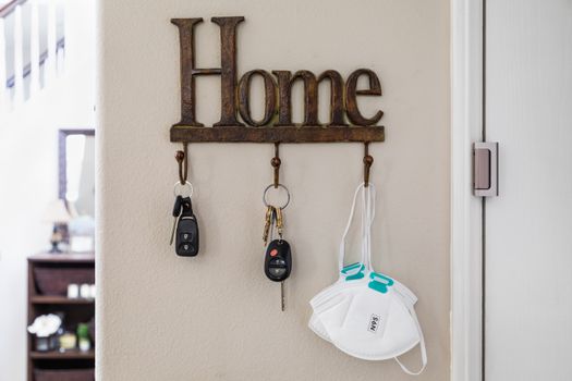 Home Key Hanger Rack Next to Door With Keys and Medical Face Mask During Coronavirus Pandemic.