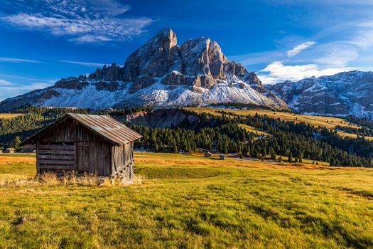 Stunning view of Peitlerkofel mountain from Passo delle Erbe in Dolomites, Italy. View of Sass de Putia (Peitlerkofel) at Passo delle Erbe, with wooden farm houses, Dolomites, South Tyrol, Italy.