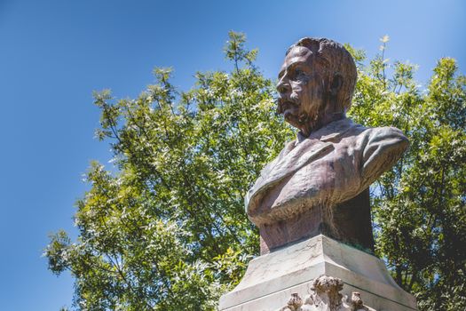 Evora, Portugal - May 5, 2018: View of a public garden on a spring day with a statue of Francisco Eduardo de Barahona Fragoso sculpted by the Portuguese Jose Simoes de Almeida