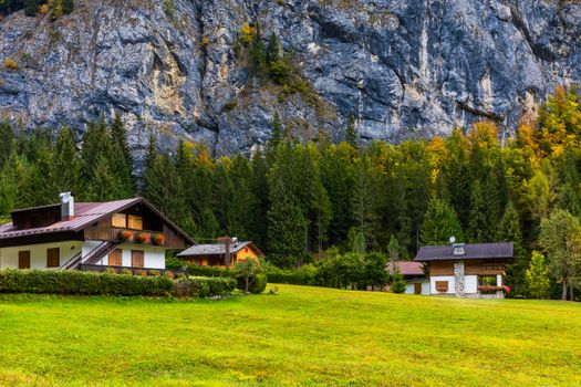 Autumn in the famous Dolomites mountains, Italy, Europe. Dramatic cliffs surround the village with the the iconic mountains and autumn forest. Colorful autumn landscape in mountain village. 