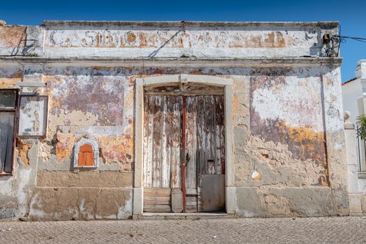 Setubal, Portugal - August 8, 2018: Old worn wooden door on a ruined building in the center of Setubal on a summer day