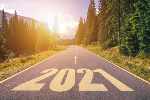 Empty asphalt road and New year 2021 concept. Driving on an empty road in the mountains to upcoming 2021 and leaving behind old 2020. Concept for success and passing time.