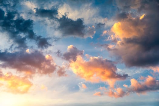 Beautiful sunset sky above clouds with dramatic light. Sunset sky for background, sunrise sky and clouds. Bright orange and blue sky and light of the sun. Beautiful sky with cloud before sunset.