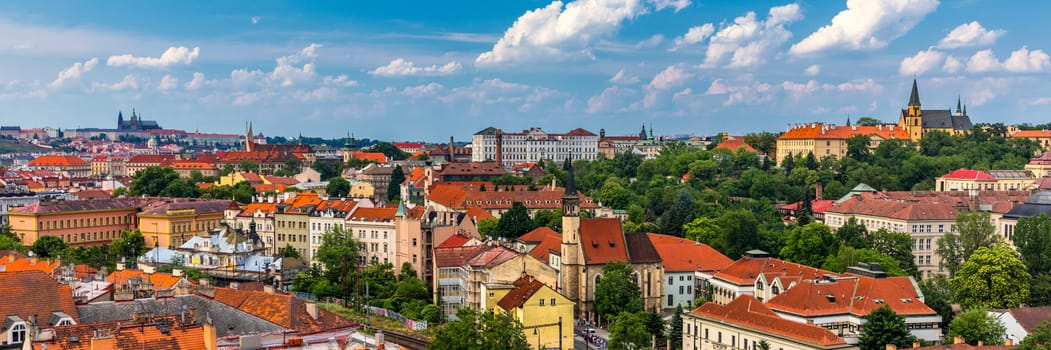 View of Prague Castle over red roof from Vysehrad area at sunset lights, Prague, Czech Republic. Scenic view of Prague city, Prague castle and Petrin tower from Vysehrad overlooking red roofs 