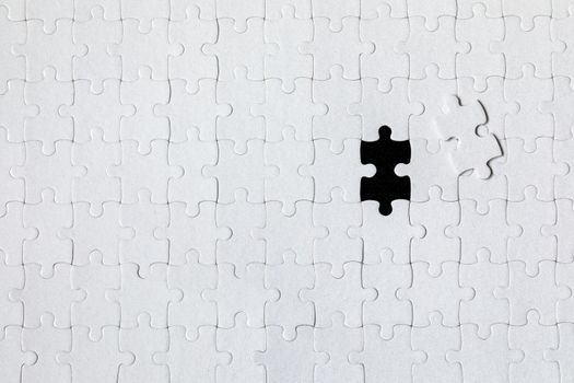 White jigsaw puzzle. White puzzle pieces on color background. Unfinished white jigsaw puzzle pieces on color background. 