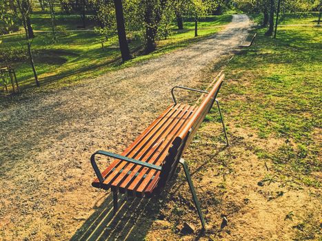 Empty bench in park during a city lockdown in coronavirus pandemic, outdoors and social issue