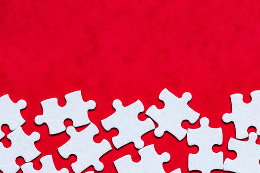 White jigsaw puzzle. White puzzle pieces on color background. Unfinished white jigsaw puzzle pieces on color background. 