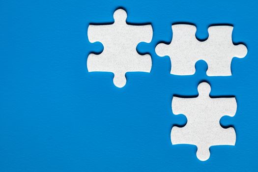 White jigsaw puzzle. White puzzle pieces on color background. Unfinished white jigsaw puzzle pieces on color background. 