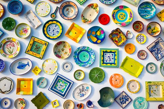 Collection of colorful Portuguese ceramic pottery, local craft products from Portugal. Ceramic plates display in Portugal. Colorful of vintage ceramic plates in Sagres, Portugal.