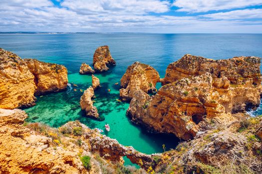 Panoramic view, Ponta da Piedade near Lagos in Algarve, Portugal. Cliff rocks and tourist boat on sea at Ponta da Piedade, Algarve region, Portugal. Ponta da Piedade, Algarve region, Portugal.