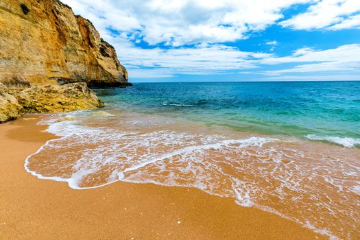 Soft wave of blue ocean on sandy tropical beach. Background of tropical paradise beach with golden sand, travel tourism panorama background concept. Sand and sea waves background.