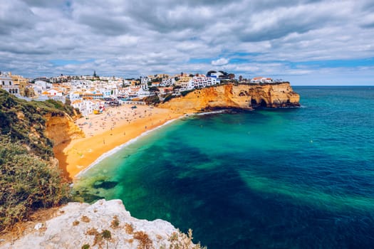 View of Carvoeiro fishing village with beautiful beach, Algarve, Portugal. View of beach in Carvoeiro town with colorful houses on coast of Portugal. The village Carvoeiro in the Algarve Portugal.