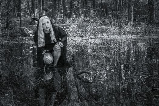 A gorgeous gothic model acts in a forest environment