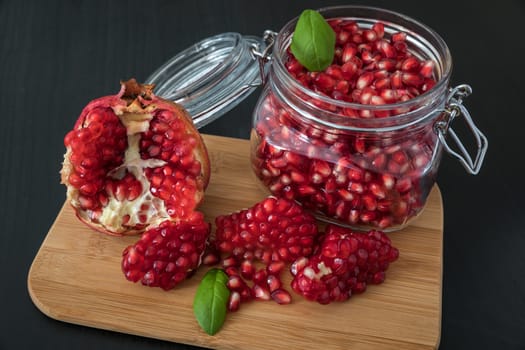 Ripe pomegranate fruit in a jar on wooden vintage background