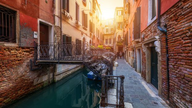 View of the street canal in Venice, Italy. Colorful facades of old Venice houses. Venice is a popular tourist destination of Europe. Venice, Italy.