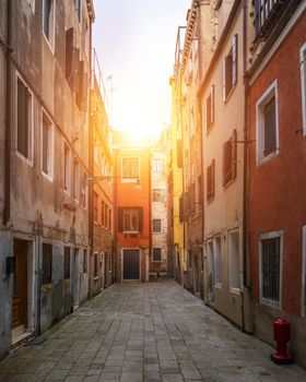 Street in Venice, Italy. Narrow street among old colorful brick houses in Venice, Italy. Venice postcard