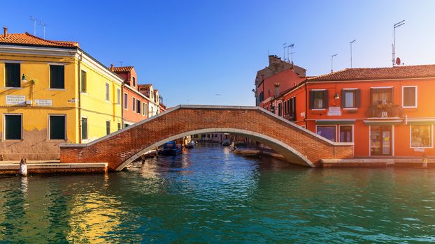 Street canal in Murano island, Venice. Narrow canal among old colorful brick houses in Murano, Venice. Murano postcard, Venice, Italy.