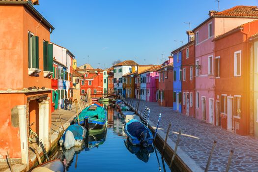 Street with colorful buildings in Burano island, Venice, Italy. Architecture and landmarks of Burano, Venice postcard. Scenic canal and colorful architecture in Burano island near Venice, Italy