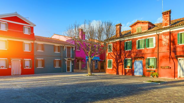 Street with colorful buildings in Burano island, Venice, Italy. Architecture and landmarks of Burano, Venice postcard. Scenic canal and colorful architecture in Burano island near Venice, Italy